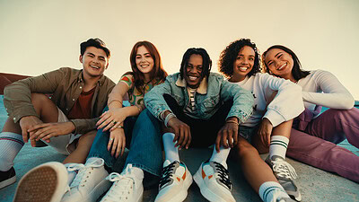 Gen Z friends sitting together outdoors, posing and smiling