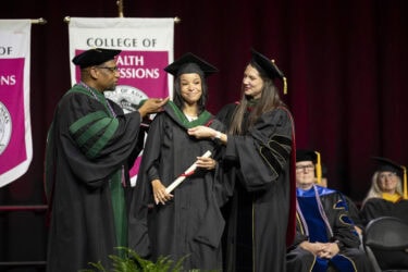 A woman receives her degree during the commencement ceremony for the UAMS College of Health Professions. A total of 743 students graduated from the college.