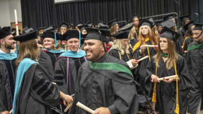 With diplomas in hand, new graduates of the College of Health Professions class of 2026 prepare to exit the Statehouse Convention Center after the commencement ceremony.