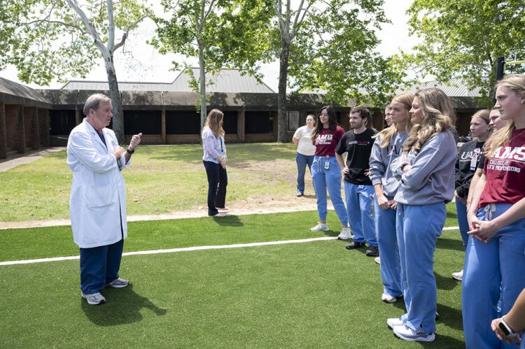 Chancellor C. Lowry Barnes, left, talks with PA students in the west campus courtyard.