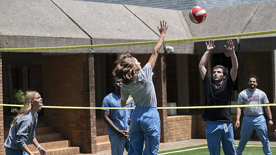 Physician Assistant Studies students play volleyball on the new court surface..