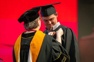 A graduate of the Bachelor of Science in Nursing program receives his pin, which symbolizes the transition from student to colleague.