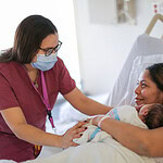 Doula talking with new mom in hospital.