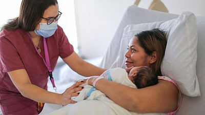Doula talking with new mom in hospital.