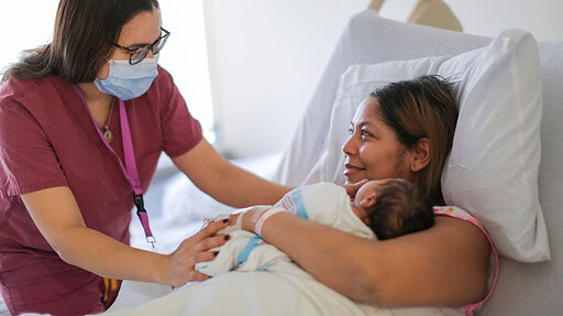 Doula talking with new mom in hospital.
