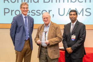 Dr. Brimberry receives award from Dr. Rakel and Dr. Kraleti