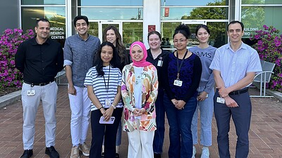 Abdel Fouda, Ph.D., right, and members of his laboratory, standing outside.