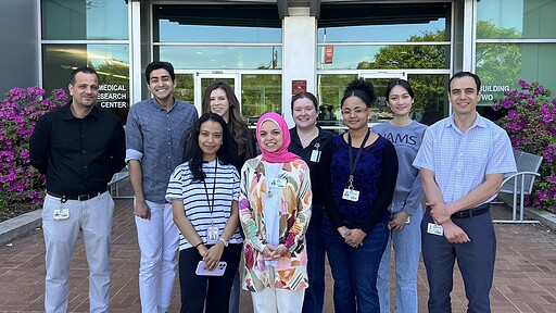 Abdel Fouda, Ph.D., right, and members of his laboratory, standing outside.