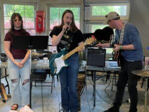 Isabel Wood, a former NICU preemie, performs with an electric guitar.