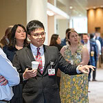 Residents discuss a research poster at the conference