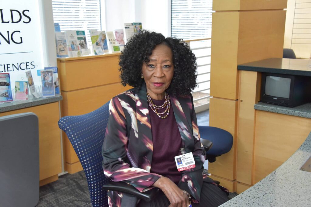 Susie Whittington sits at the front desk in the lobby of the UAMS Donald W. Reynolds Institute on Aging, where she directs patients to their appointments and offers words of encouragement and comfort.