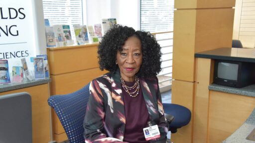 Susie Whittington sits at the front desk in the lobby of the UAMS Donald W. Reynolds Institute on Aging, where she directs patients to their appointments and offers words of encouragement and comfort.