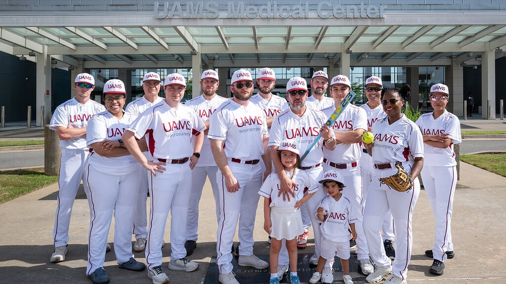 <p>Members of the UAMS Department of Neurosurgery softball team pose before the tournament, with Sophia and Santiago, the son and daughter of coach Hector Soriano, M.D.</p>
<div><a class="more" href="https://news.uams.edu/2026/06/17/uams-neurosurgeons-trade-scalpels-for-bats-at-national-softball-tournament/uams-neurosurgery-softball-team-06012026-dsc_0460/">Read more</a></div>