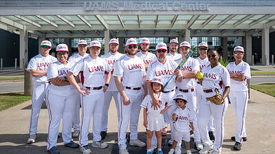 Members of the UAMS Department of Neurosurgery softball team pose before the tournament, with Sophia and Santiago, the son and daughter of coach Hector Soriano, M.D.