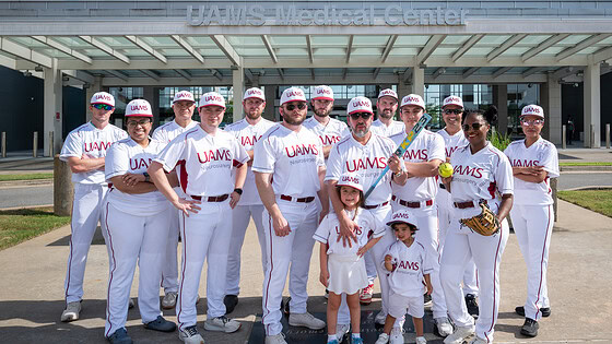 Members of the UAMS Department of Neurosurgery softball team pose before the tournament, with Sophia and Santiago, the son and daughter of coach Hector Soriano, M.D.