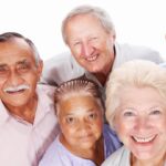 A group of five older adults — two women and three men — poses for a group photo in this stock image.