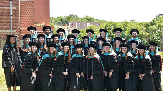 The UAMS Doctor of Physical Therapy class of 2026 poses in their regalia on the UAMS Northwest Campus lawn.