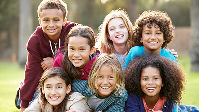 Stock image of seven children in a group smiling.