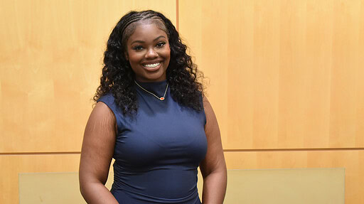 Malayah Lee stands in front of a wall in the Daniel W. Rahn Interprofessional Education Building at UAMS.