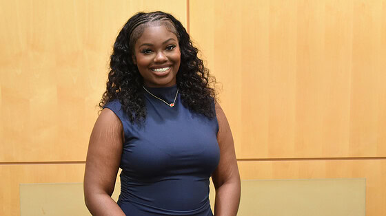 Malayah Lee stands in front of a wall in the Daniel W. Rahn Interprofessional Education Building at UAMS.