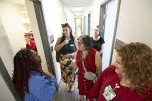 Five people, including some UAMS employees, stand in a hallway during a tour of the new clinic