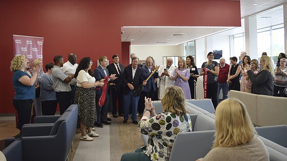 UAMS Chancellor C. Lowry Barnes, M.D., smiles as onlookers clap after he cuts the ribbon to formally open the newest and largest UAMS Health Orthopaedics & Sports Clinic.