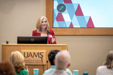College of Nursing Dean Sarah Rhoads, shown speaking at the lectern, said the lecture provided an opportunity for students to see how they can use their education to improve the lives of others.