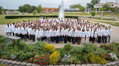 Group photo in front of UAMS fountain of UAMS College of Medicine Class of 2026 in white coats