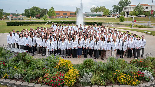 Group photo in front of UAMS fountain of UAMS College of Medicine Class of 2026 in white coats