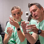 Two MASH students learn how to draw medicine from a vial from an instructor.