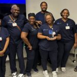 Members of the University of Arkansas for Medical Sciences (UAMS) medline group pose after being presented with the Barbershop Talk Wellness Challenge trophy. They earned the award due to finishing at the top of the team rankings. Camille Hart, MPH, (far right) Barbershop Talk research program director is shown alongside the team.