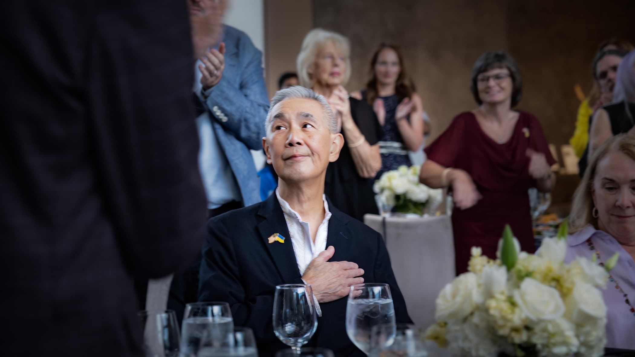 James Suen, M.D., puts his hand over his heart in appreciation for the applause he is receiving at the Becoming Whole charity event Aug. 27 in Dallas.