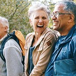 Older adults talking and laughing in a park.