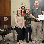 Nathan Johnson, center, holds his Patriotic Employer Award certificate. Congratulating him are left to right, Sarah Parker, Cherika Robertson, Rebecca Bird, (Johnson), retired Col. Tom Anderson, Corinne Hollingsworth and Thao Vu. Except for Anderson, all are faculty members of the Department of Laboratory Sciences.