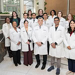A group shot of about 20 of the stroke providers, all in white coats, standing inside UAMS, posed.