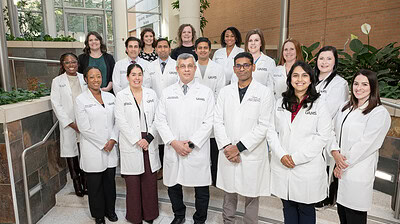 A group shot of about 20 of the stroke providers, all in white coats, standing inside UAMS, posed.