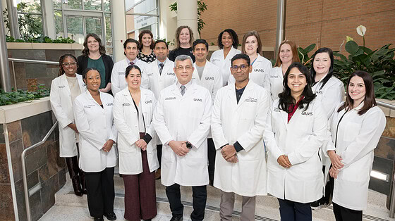 A group shot of about 20 of the stroke providers, all in white coats, standing inside UAMS, posed.
