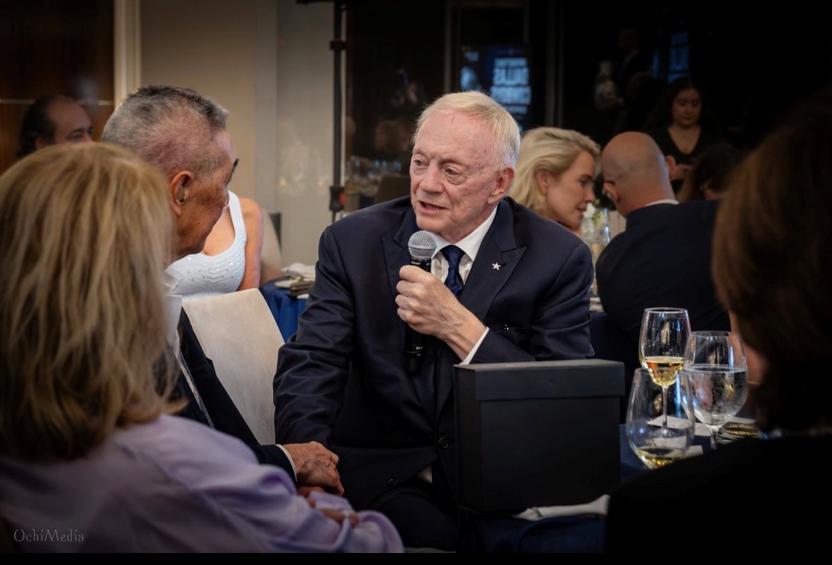 Jerry Jones, owner of the Dallas Cowboys football team, shakes hands with Suen while speaking to the audience at the Becoming Whole event on Aug. 27 in Dallas.