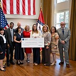 Arkansas Gov. Sarah Sanders (center right) presents UAMS with a check in the second round of Rural Health Transformation Program (RHTP) grants.
