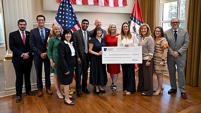 Arkansas Gov. Sarah Sanders (center right) presents UAMS with a check in the second round of Rural Health Transformation Program (RHTP) grants.