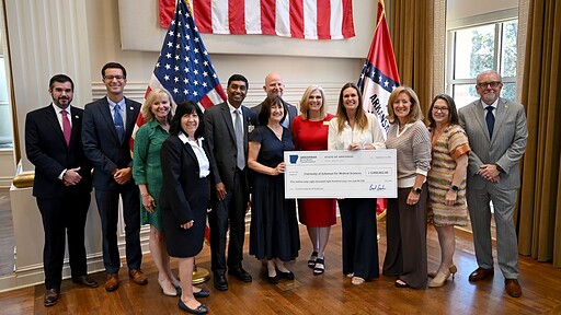 Arkansas Gov. Sarah Sanders (center right) presents UAMS with a check in the second round of Rural Health Transformation Program (RHTP) grants.