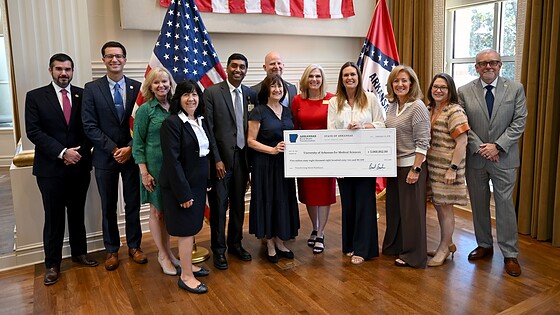 Arkansas Gov. Sarah Sanders (center right) presents UAMS with a check in the second round of Rural Health Transformation Program (RHTP) grants.