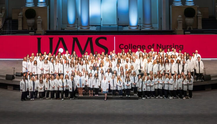 Sarah Rhoads (front center), dean of the College of Nursing, takes a group photo with all the students who received their white coats.
