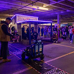 One of the kids who received a Go Baby Go car drives toward the mini 7Brew drive thru replica that was built for the distribution event.