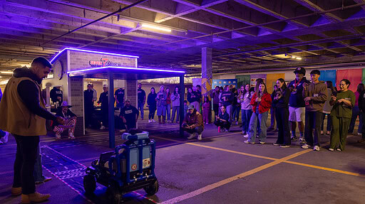 One of the kids who received a Go Baby Go car drives toward the mini 7Brew drive thru replica that was built for the distribution event.