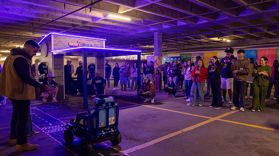 One of the kids who received a Go Baby Go car drives toward the mini 7Brew drive thru replica that was built for the distribution event.