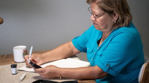 Woman using a remote glucose monitor