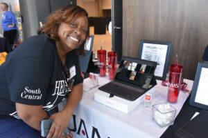 Summer Jamison with UAMS South Central Regional Campus, smiles in front of her booth.