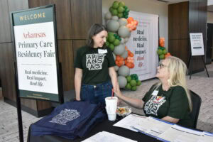 Jessica Bursk, event planner, talks with Heidi Damron at sign-in desk.